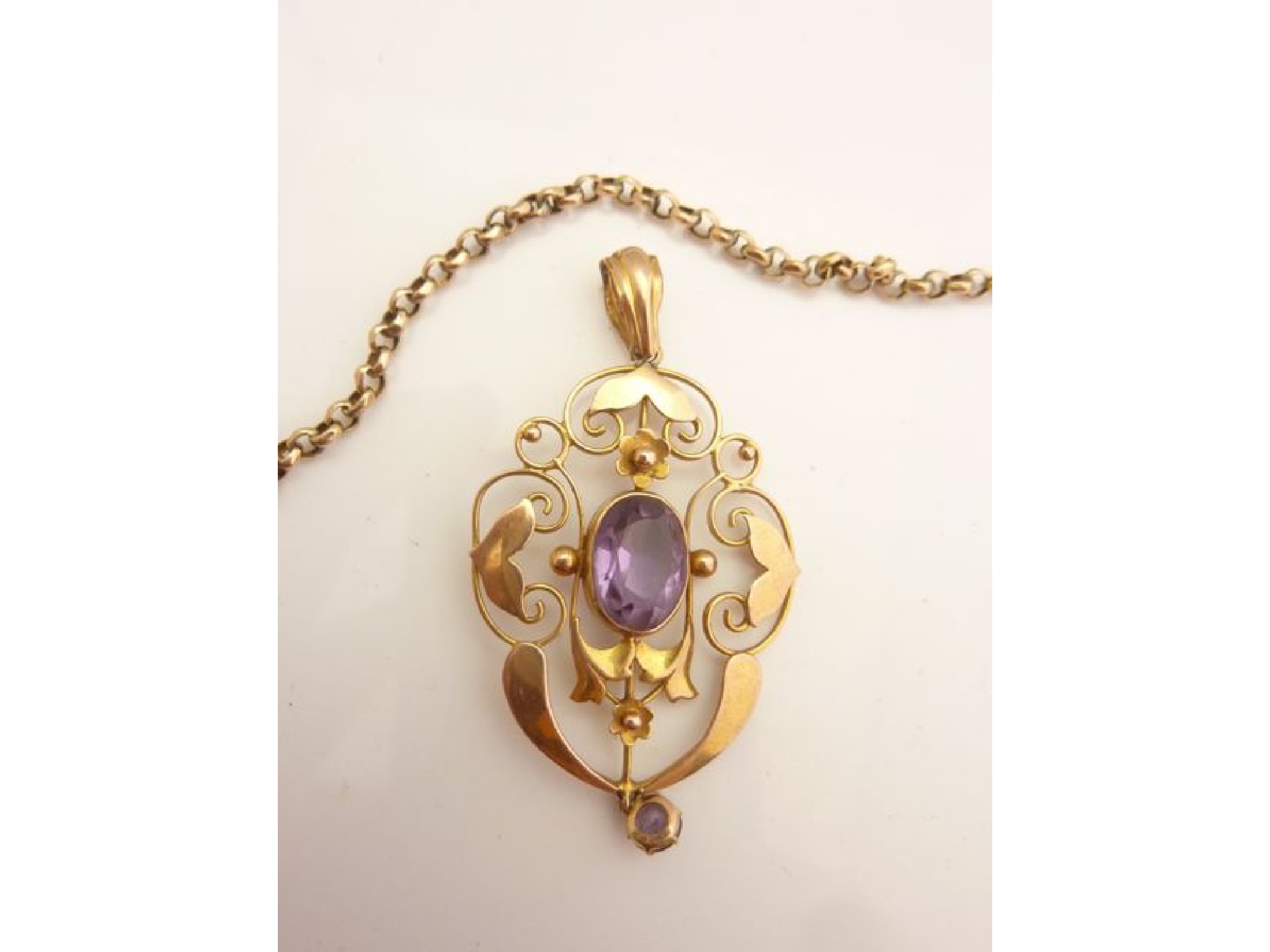 Appraisal: An Edwardian pendant centred with an oval mixed-cut amethyst weighing