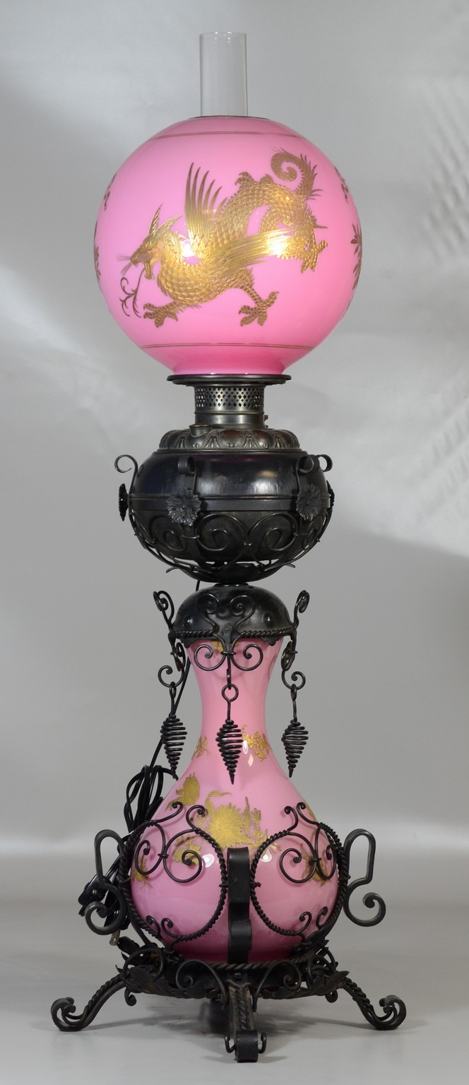 Appraisal: Pink glass and black painted metal oil lamp ornate filigree