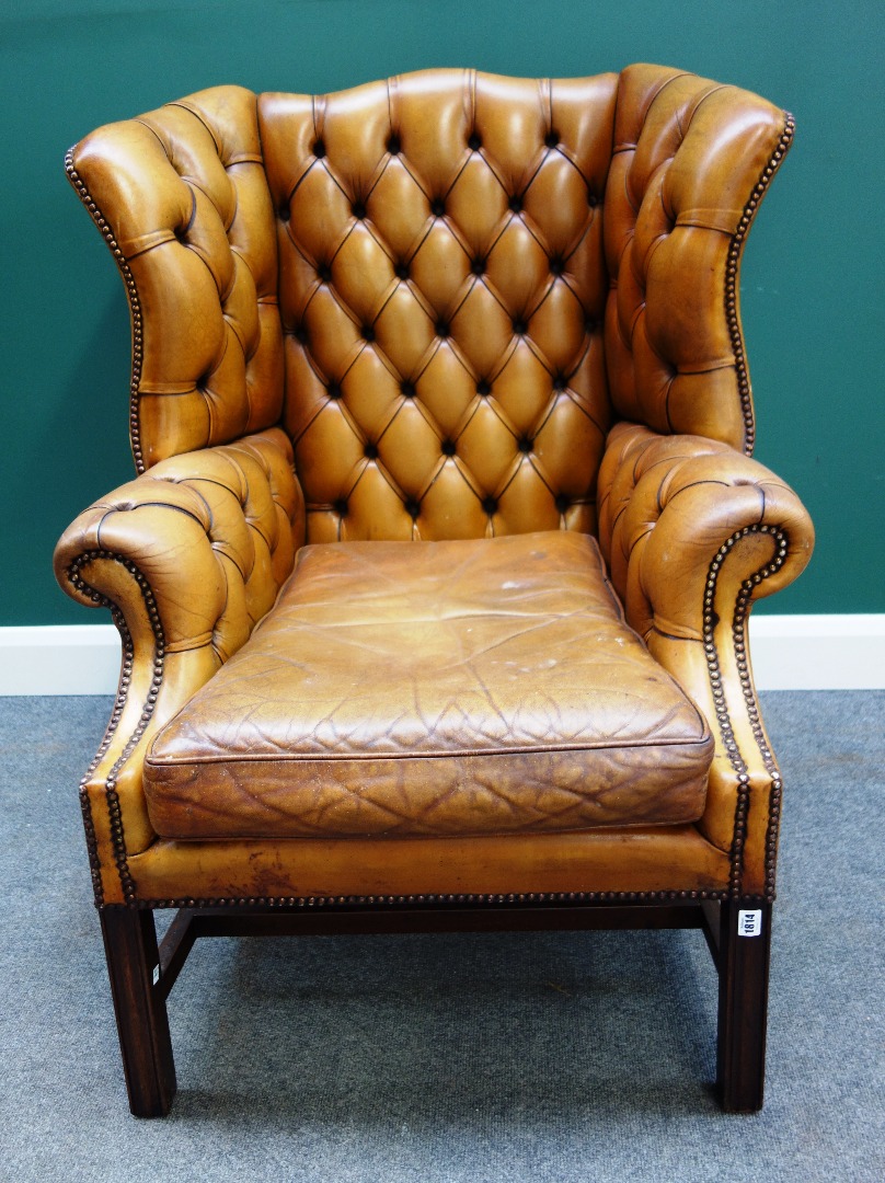 Appraisal: An th century style brown leather upholstered wingback armchair on