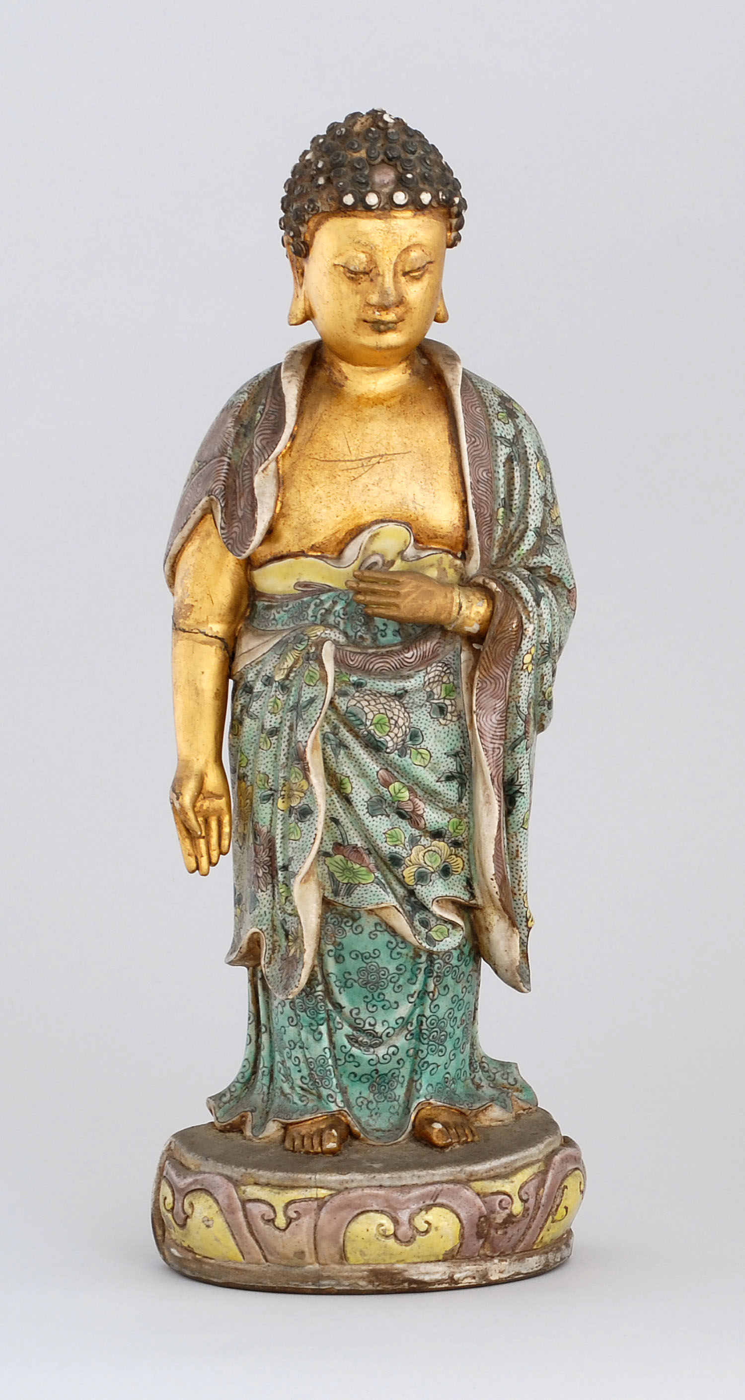 Appraisal: PORCELAIN FIGURE OF BUDDHA Kangxi PeriodIn standing posture wearing famille