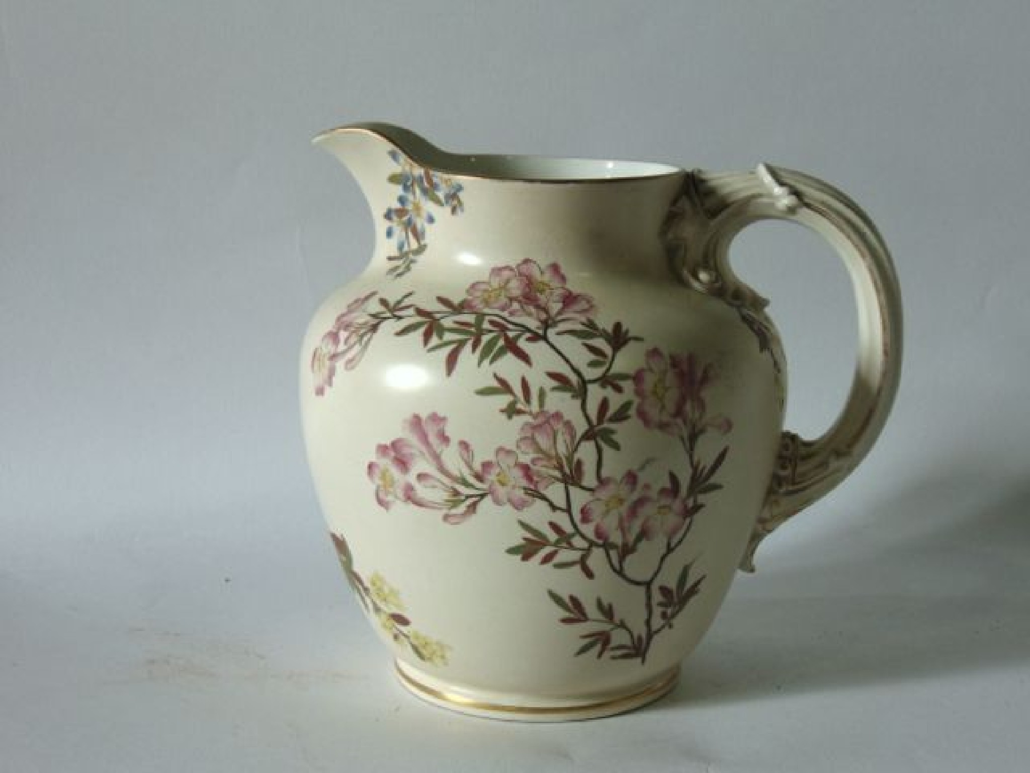 Appraisal: An ivory ground Royal Worcester jug with painted and gilded