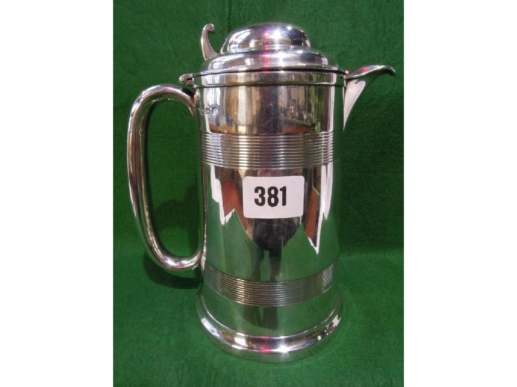 Appraisal: A Victorian silver lidded beer jug with two reeded bands