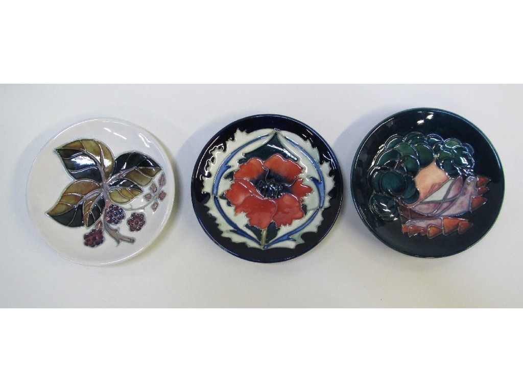 Appraisal: Three Moorcroft circular dishes decorated with poppy brambles and trees