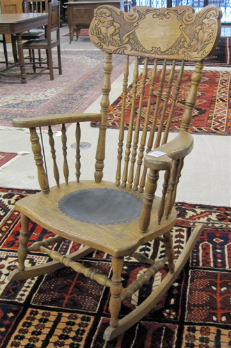 Appraisal: AN OAK PRESS-BACK ROCKER American c having a carved splat