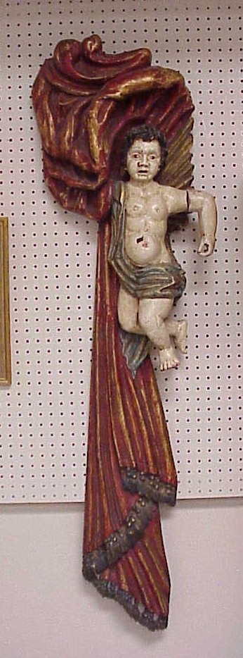 Appraisal: Carved wood hanging cherub in red and gilt drapery swag