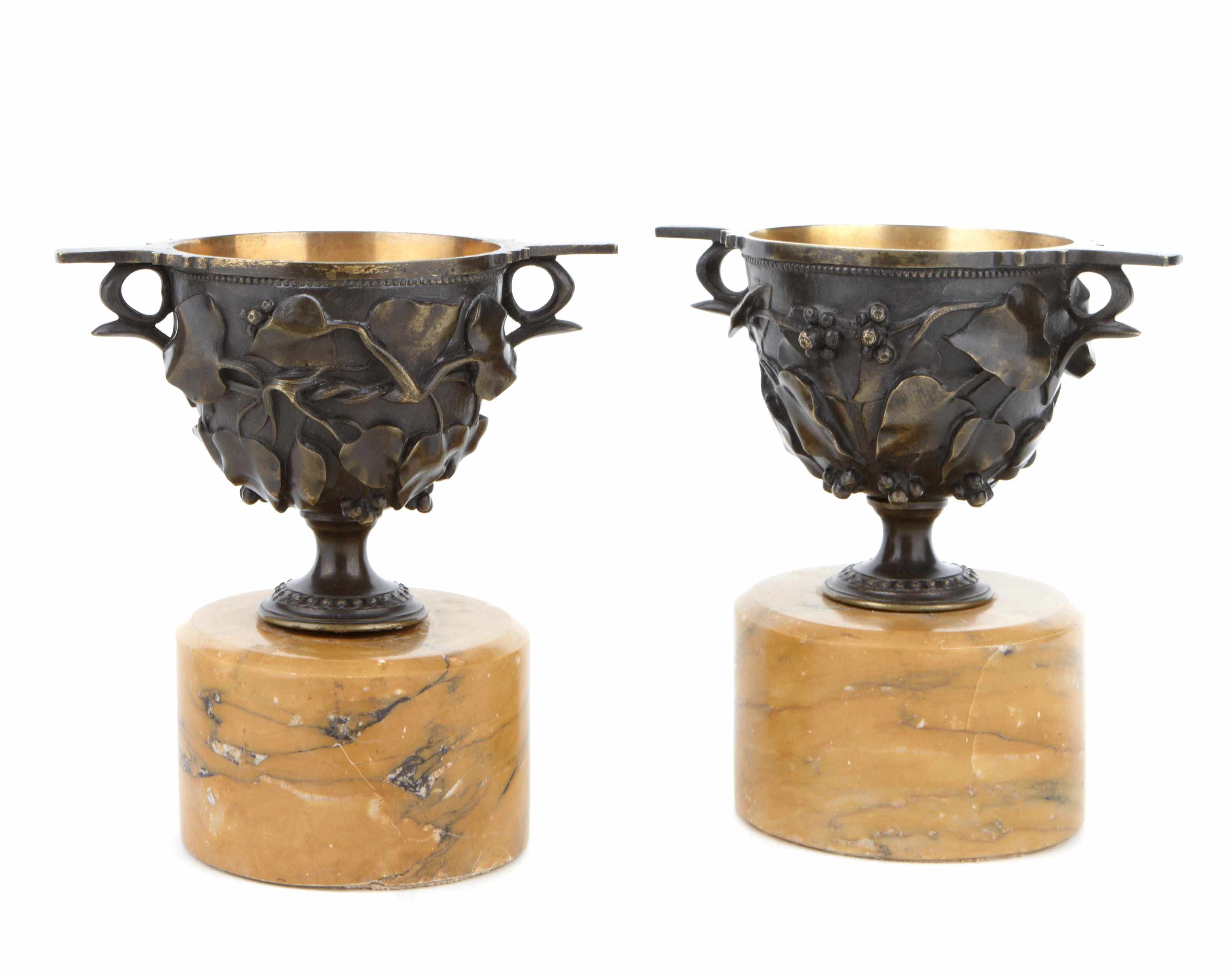 Appraisal: A pair of French patinated bronze urns on sienna marble