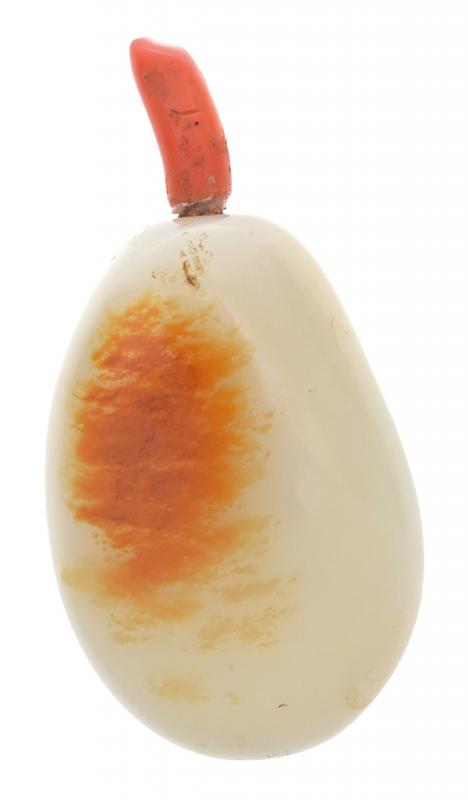 Appraisal: A RUSSET SKINNED JADE PEBBLE SNUFF BOTTLE WITH CORAL STOPPER