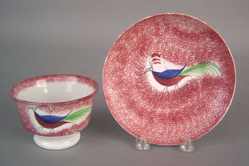 Appraisal: Red spatter cup and saucer th c with peafowl decoration