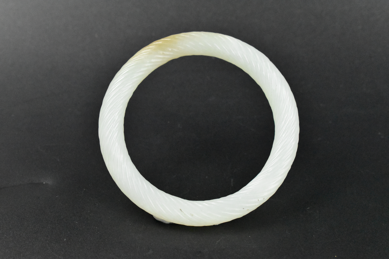 Appraisal: A Chinese white jade carved bangle dating from the Qing