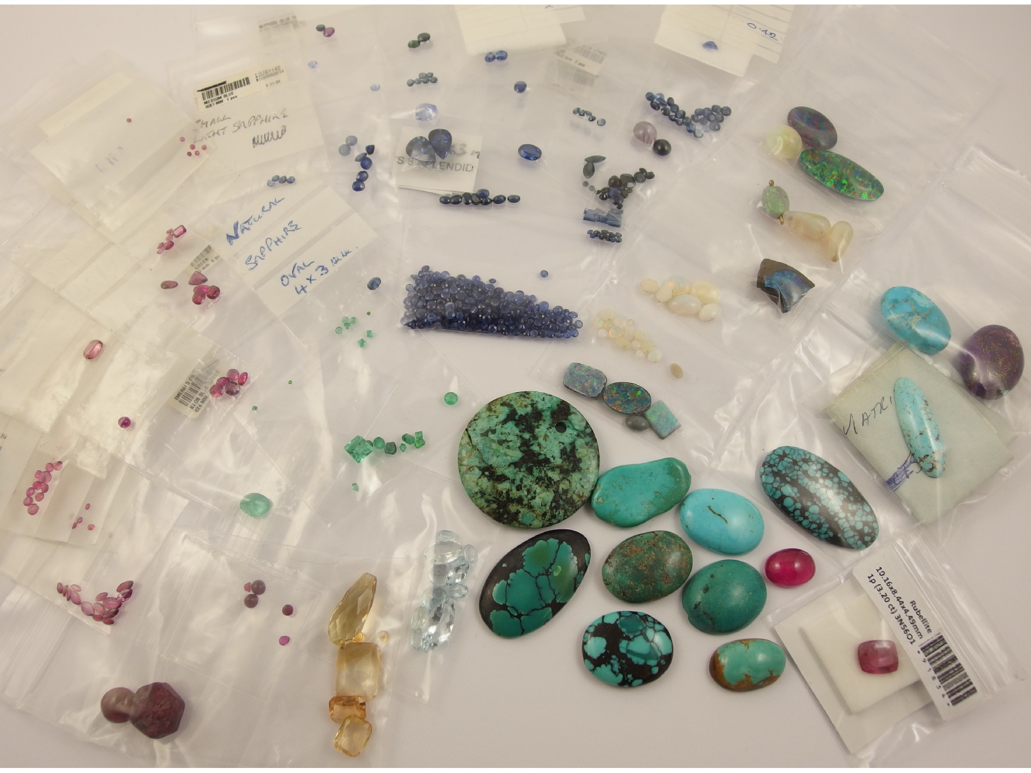 Appraisal: A rainbow collection of gemstonesto include sapphires rubies emeralds opals