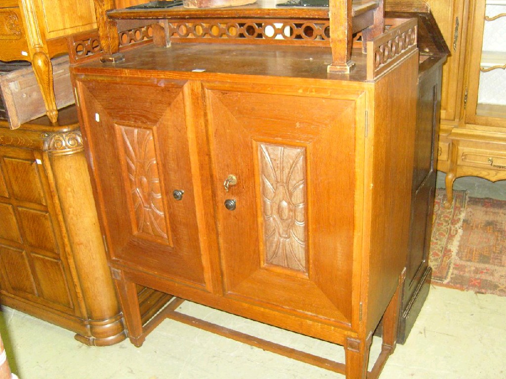 Appraisal: An Art Deco period oak side cupboard enclosed by a