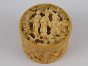 Appraisal: A small cylindrical ivory box with screwed lid deeply carved