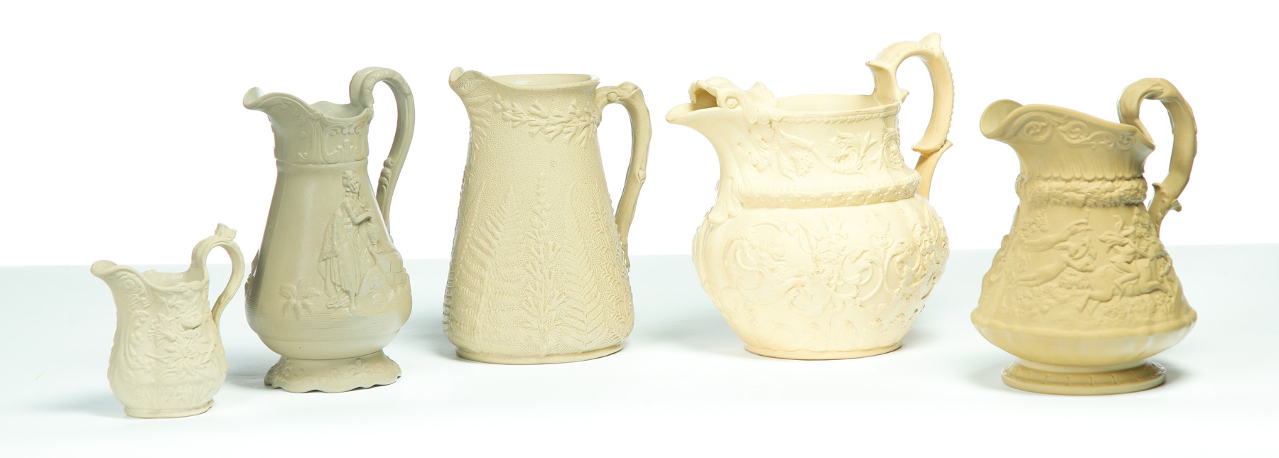 Appraisal: FIVE RELIEF MOLDED SCENIC TAN PITCHERS English mid th century