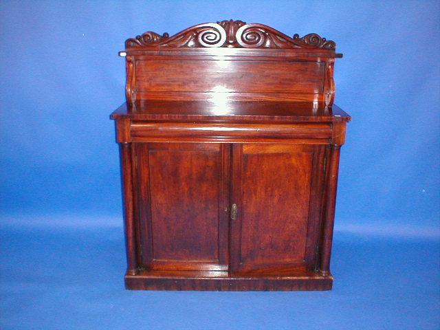 Appraisal: An early Victorian mahogany chiffonier with scroll carved back over