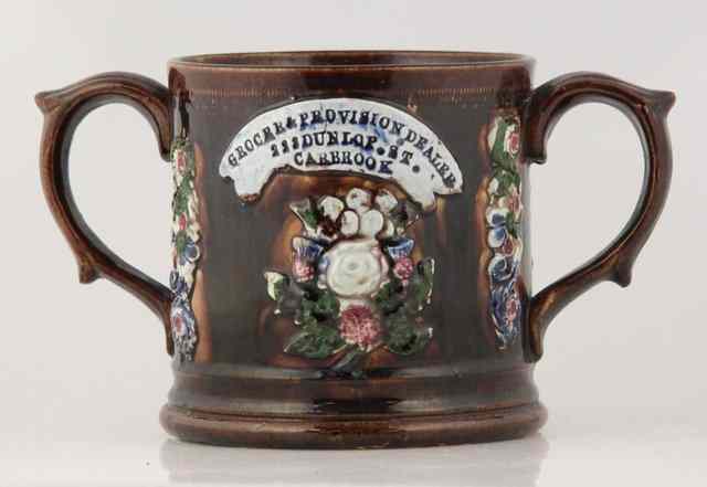 Appraisal: A Bargeware two-handled brown glaze mug Grocer and Provision Dealer