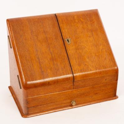 Appraisal: An oak stationery box with slope front and a fitted