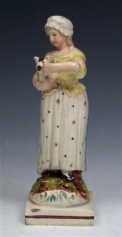 Appraisal: A CREAMWARE MODEL OF A COUNTRY GIRL holding a cat