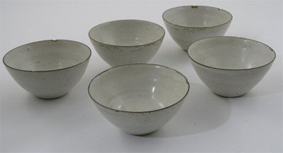 Appraisal: Lucie Rie - Five stoneware bowls pitted off-white glaze with