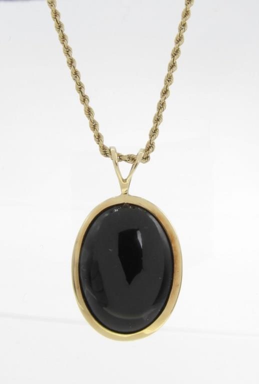 Appraisal: A K yellow gold mounted oval onyx pendant measure approximately