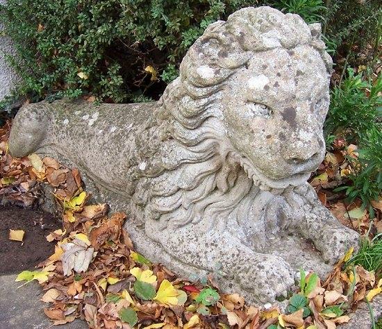 Appraisal: A pair of reconstituted stone recumbent lions cm '' long