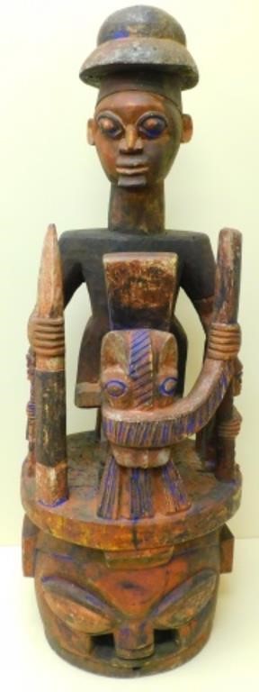 Appraisal: A CARVED AND POLYCHROME PAINTED SEATED AFRICANwarrior figure with spear