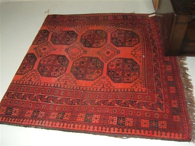 Appraisal: A Persian wine ground Bokara rug with central designs within