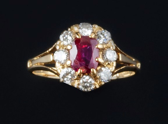 Appraisal: A ruby and diamond cluster ring the oval mixed-cut ruby