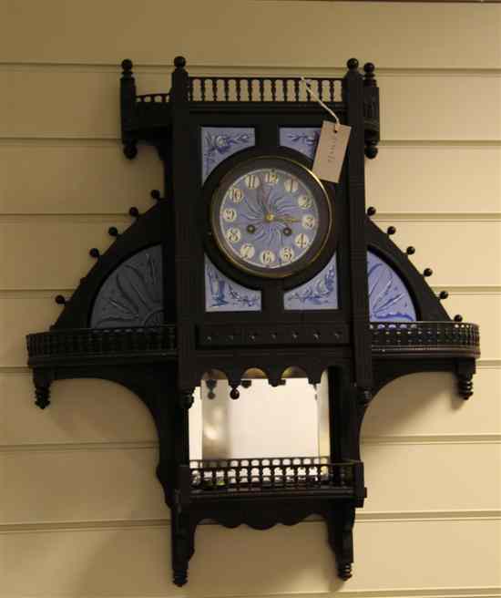 Appraisal: An Aesthetic movement ebonised wood and ceramic wall clock in