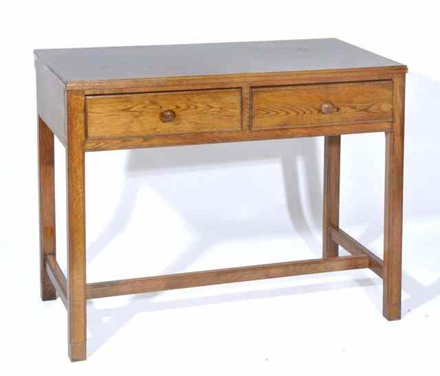 Appraisal: A COTSWOLD STYLE OAK SIDE TABLE fitted with two frieze