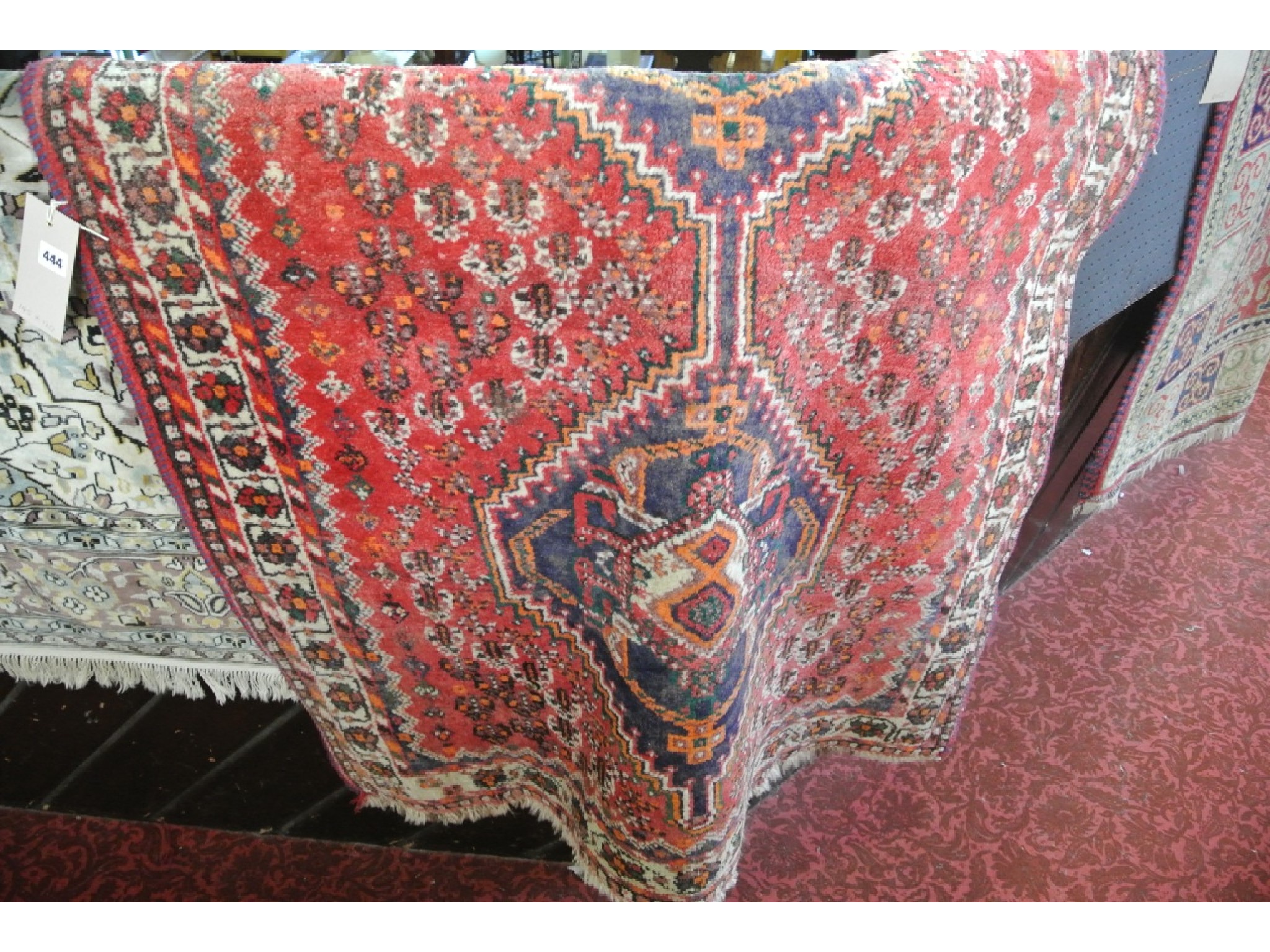 Appraisal: An Eastern red ground rug with double blue ground medallion