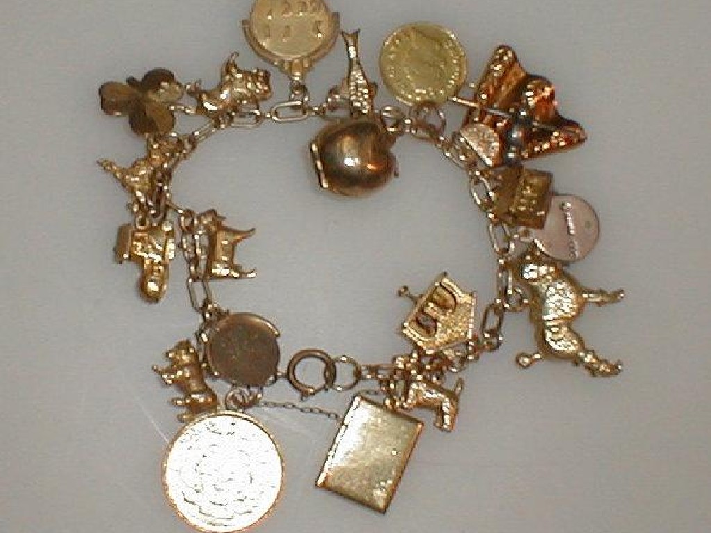 Appraisal: An open link charm bracelet with nineteen charms predominately ct