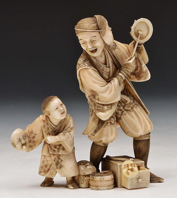 Appraisal: A Japanese ivory okimono of a street entertainer and his