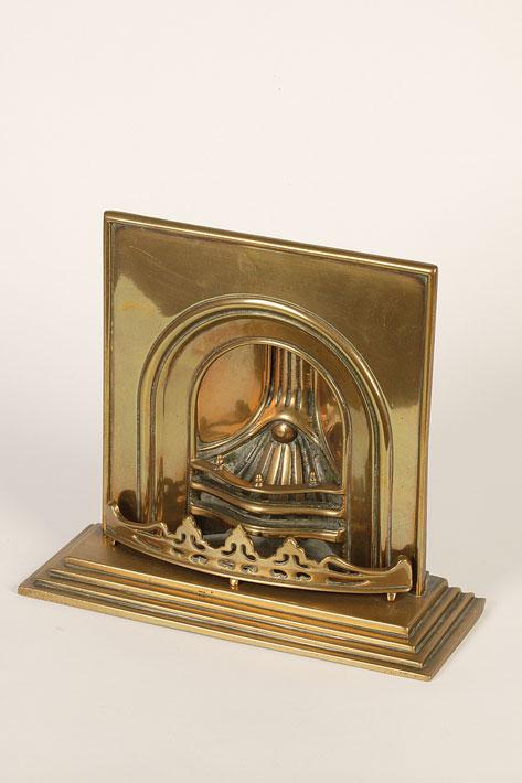 Appraisal: A CAST BRASS MINIATURE FIREPLACE with arched top and serpentine