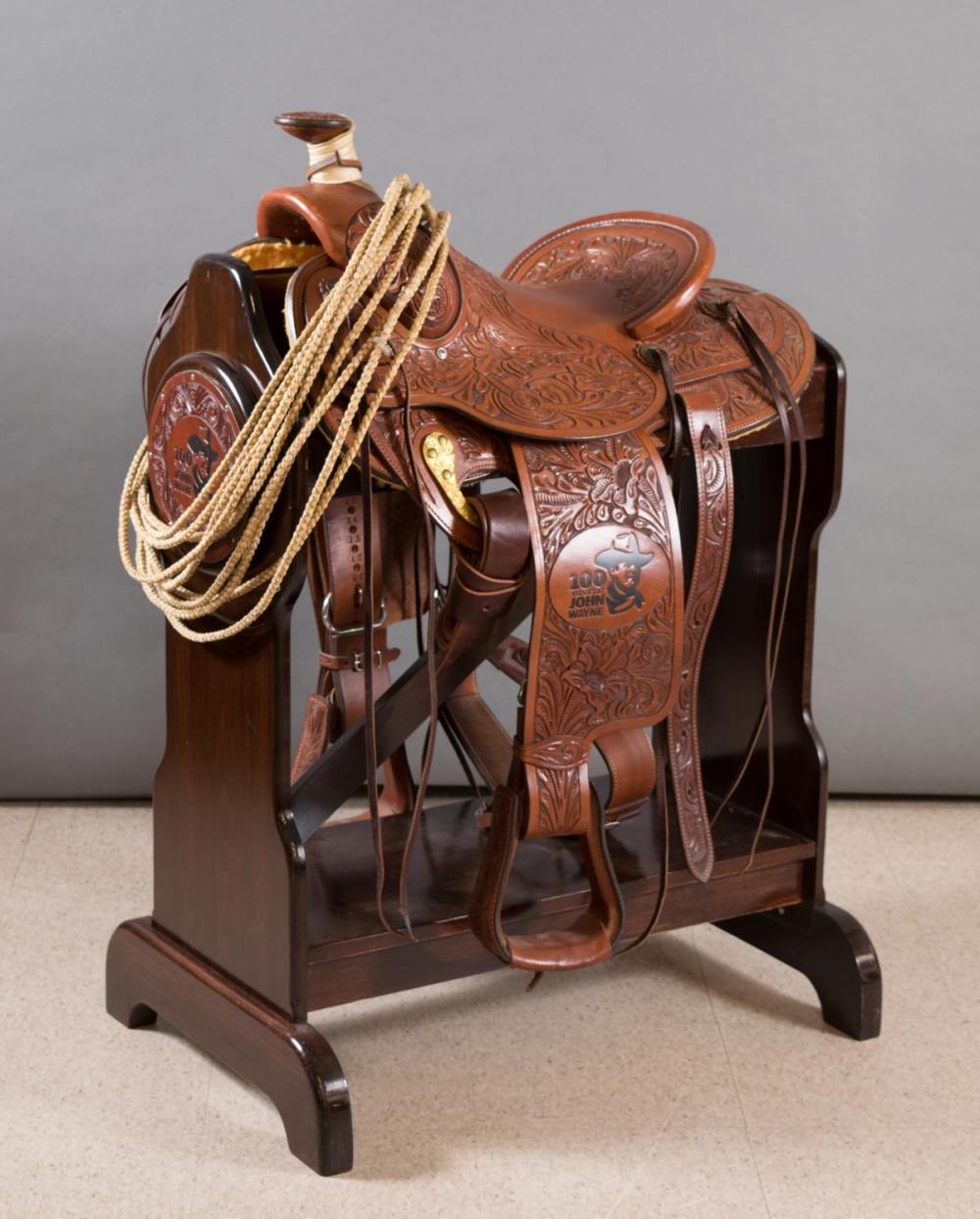 Appraisal: JOHN WAYNE COMMEMORATIVE SADDLE WITH FLOOR STAND AND ACCESSORIES Circle