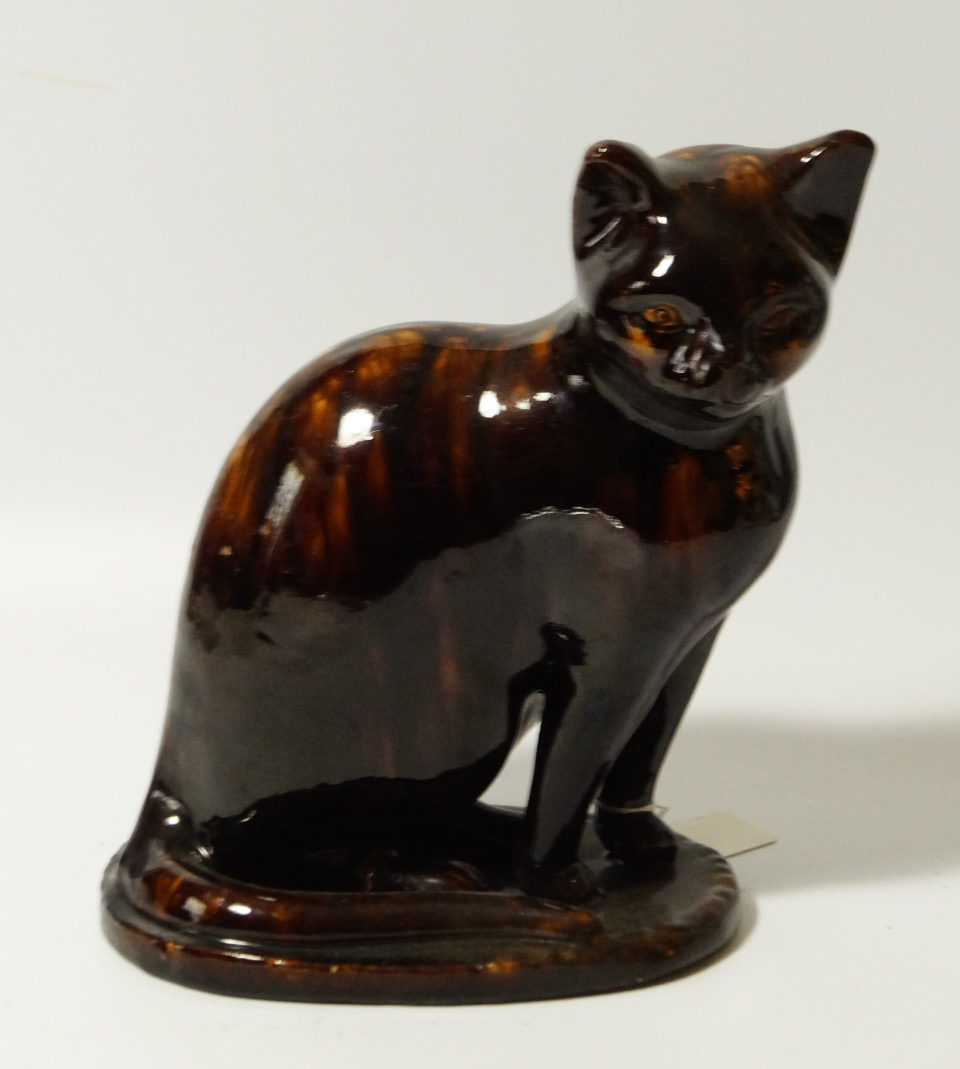 Appraisal: A thC treacle glazed pottery figure of a standing cat