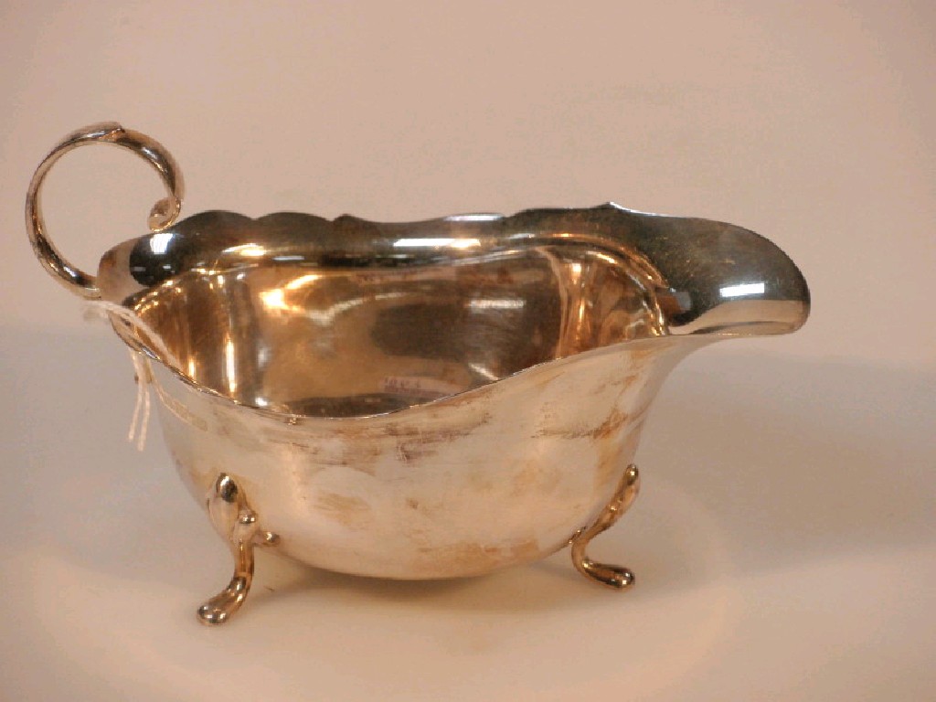 Appraisal: A modern silver sauce boat Birmingham with cut rim flying