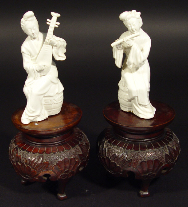 Appraisal: Two Chinese blanc-de-chine porcelain figures playing musical instruments on carved