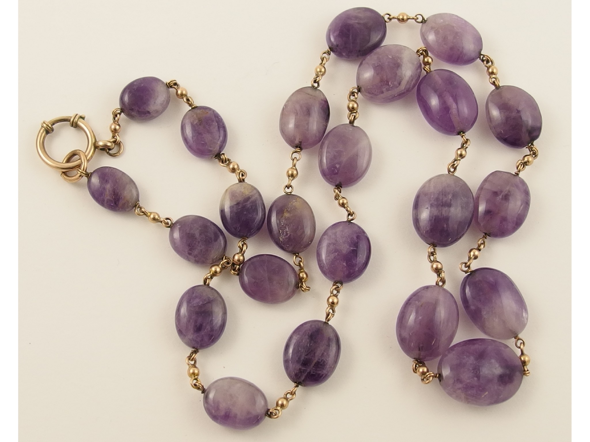 Appraisal: An amethyst bead necklaceinterspaced with yellow metal beads indistinctly hallmarked