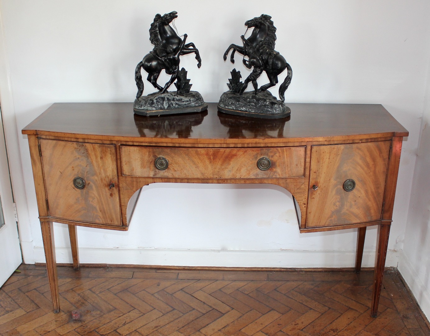 Appraisal: A George III figured mahogany sideboard the slightly bow front