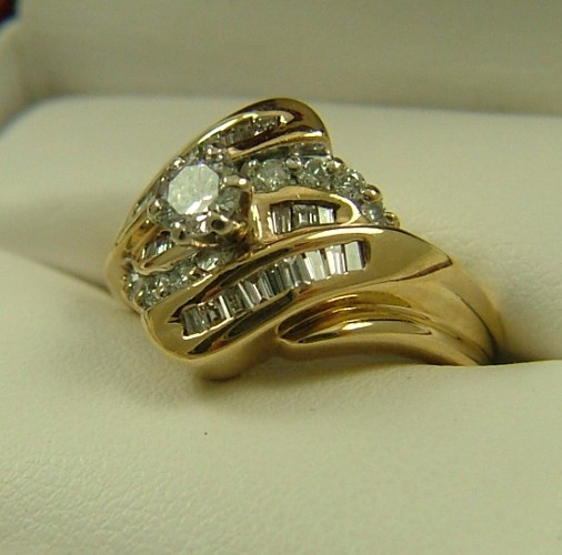 Appraisal: DIAMOND AND FOURTEEN KARAT GOLD RING centering a round brilliant-cut