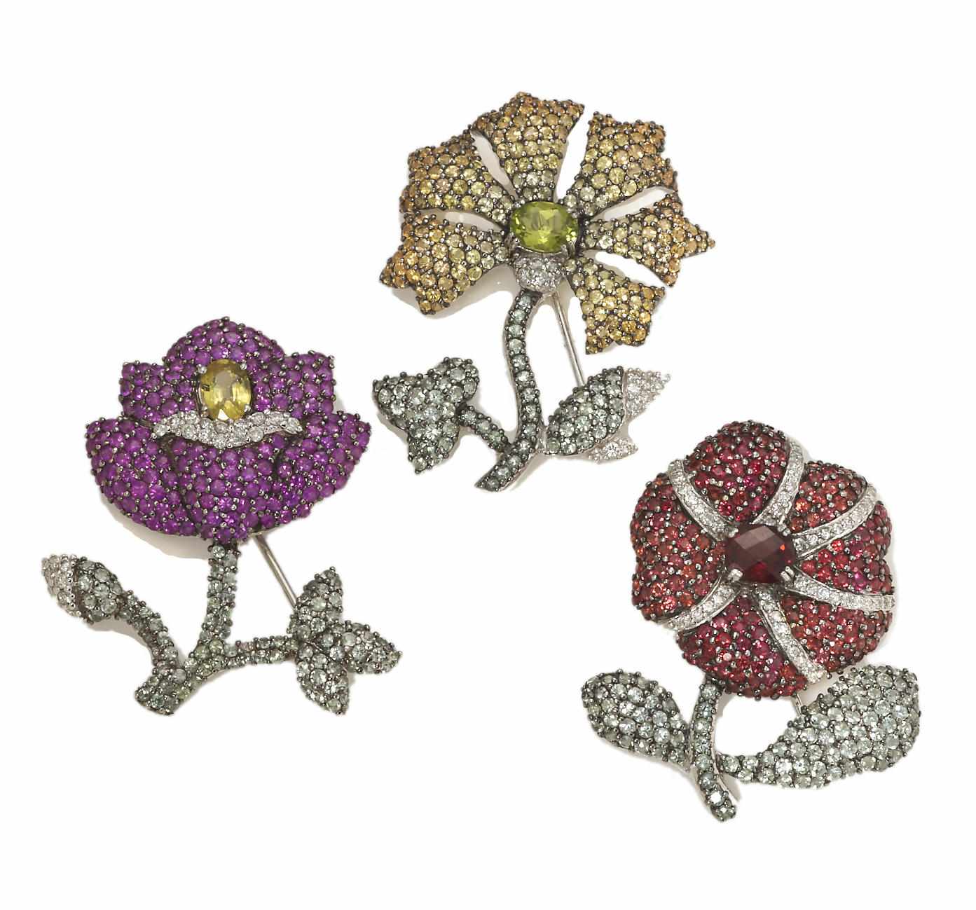 Appraisal: A collection of three diamond and gem-set flower brooches including