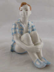 Appraisal: A Soviet Russian ceramic figure of a boy in check