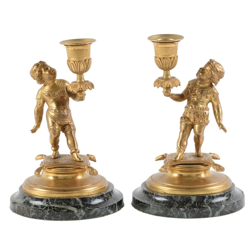 Appraisal: A pair of gilt bronze table candlesticks modelled as infants