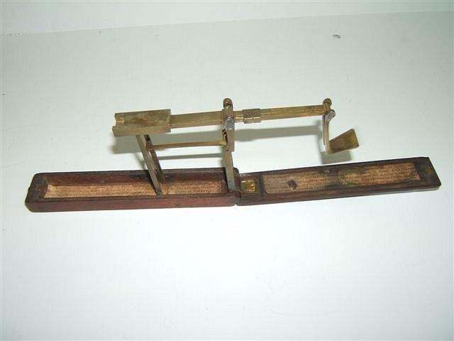 Appraisal: A GEORGE III MAHOGANY AND BRASS GUINEA SCALE the paper