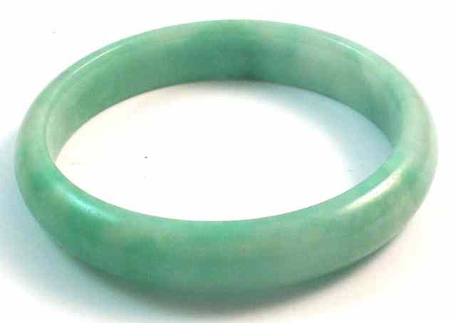 Appraisal: HEAVY LIGHT GREEN JADE BANGLE - '' in diameter inside