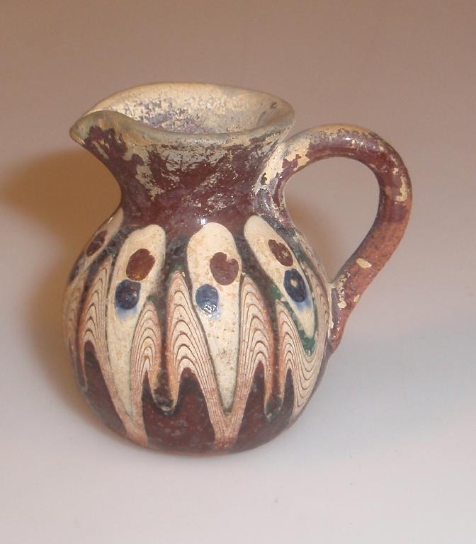 Appraisal: A miniature ancient pottery jug with pouring lip and pear-shaped