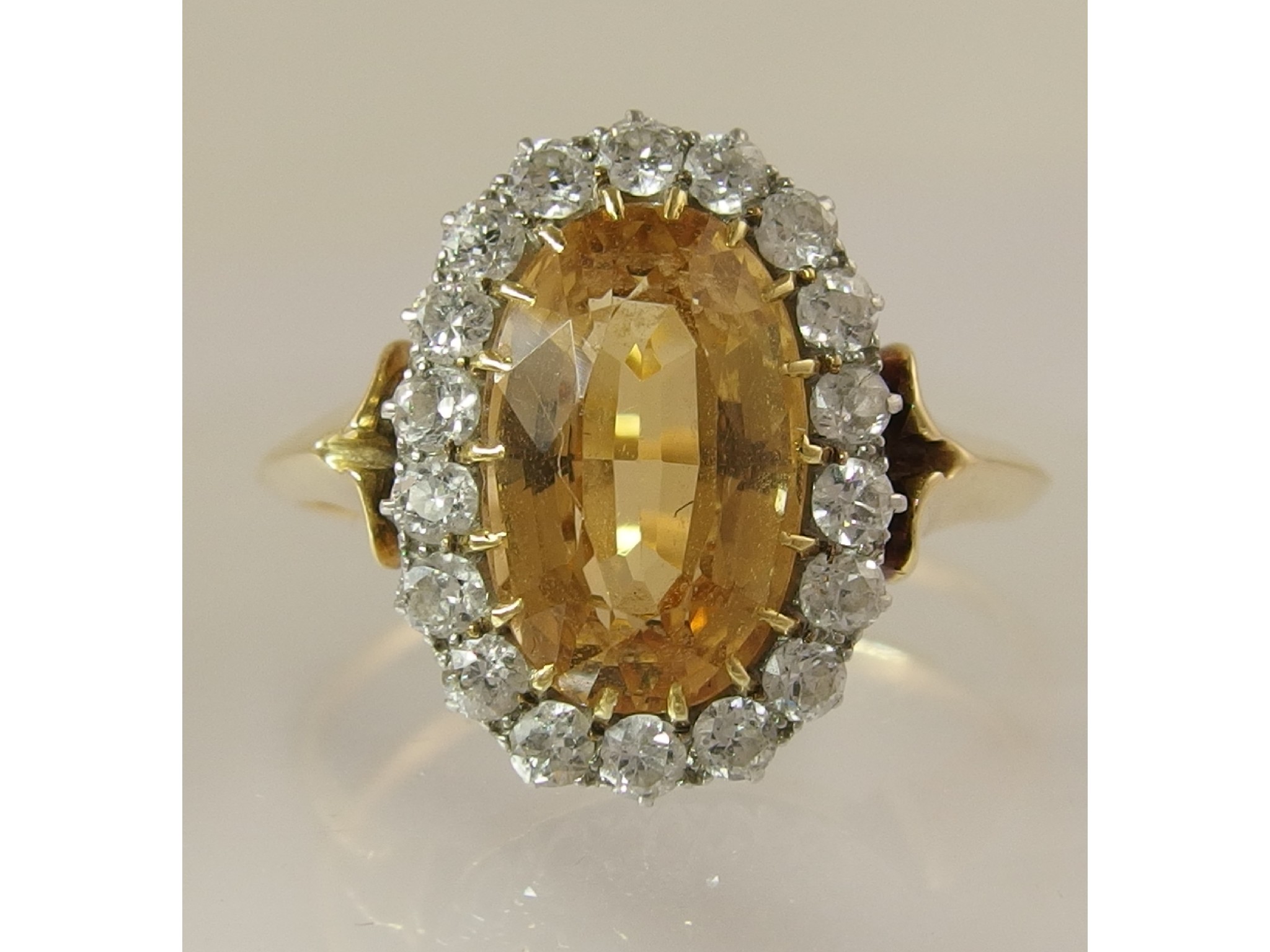 Appraisal: A yellow gem and diamond cluster ringwith unusual Arts Crafts