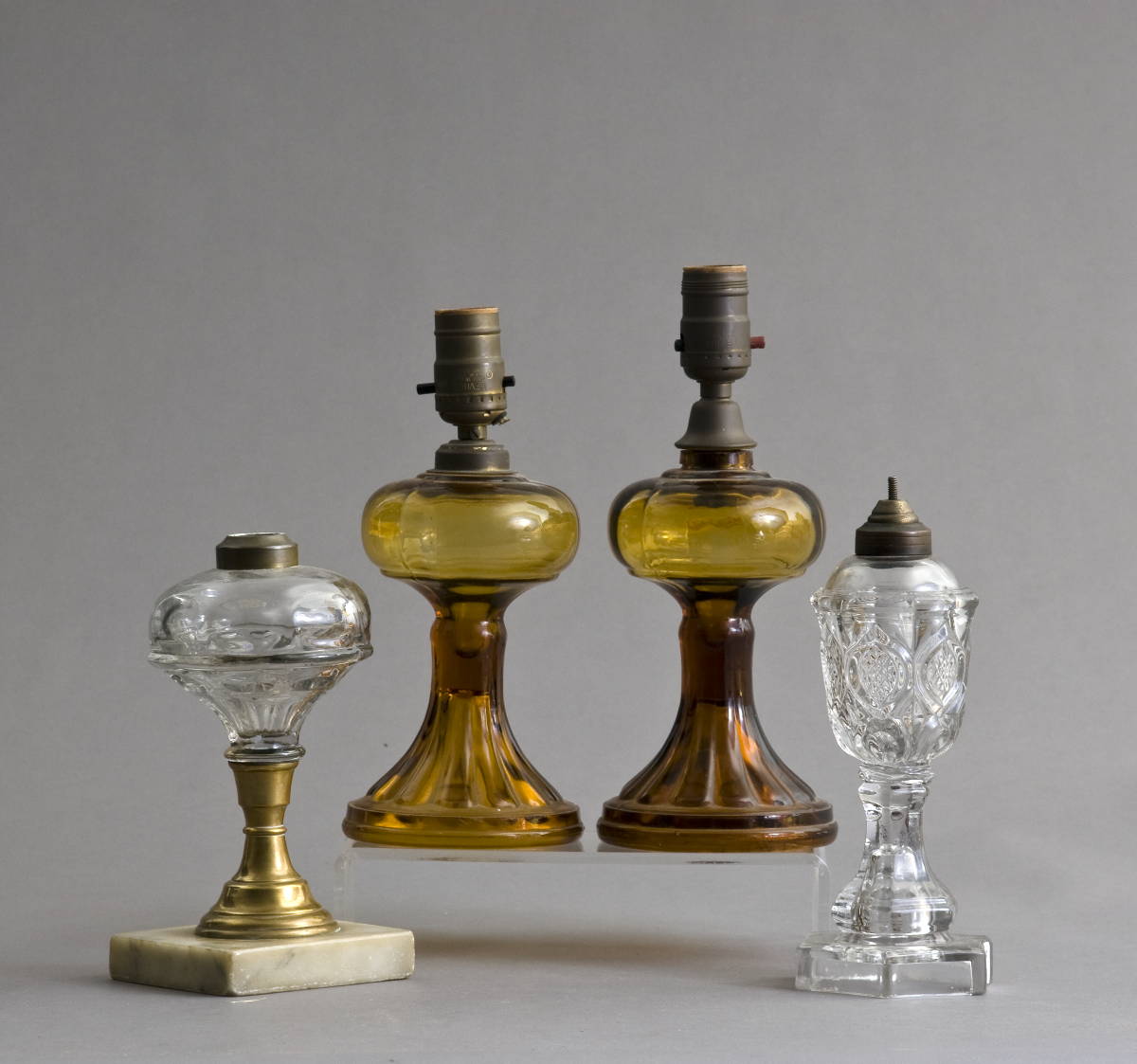 Appraisal: FOUR PRESSED GLASS FLUID LAMPS INCLUDING A PAIR OF AMBER