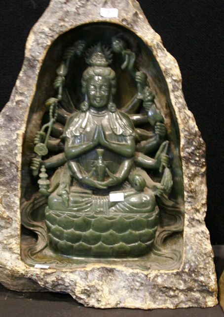 Appraisal: A carved jade figure of an eighteen armed deity holding