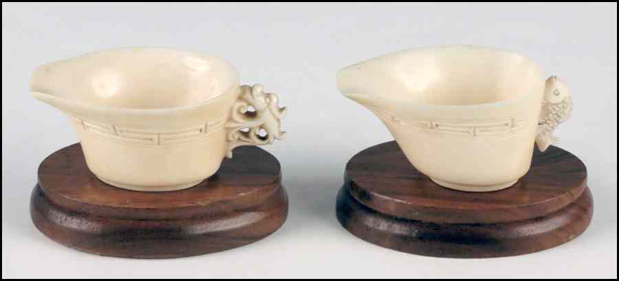 Appraisal: TWO CARVED IVORY HANDLED CUPS One cup bearing a dragon